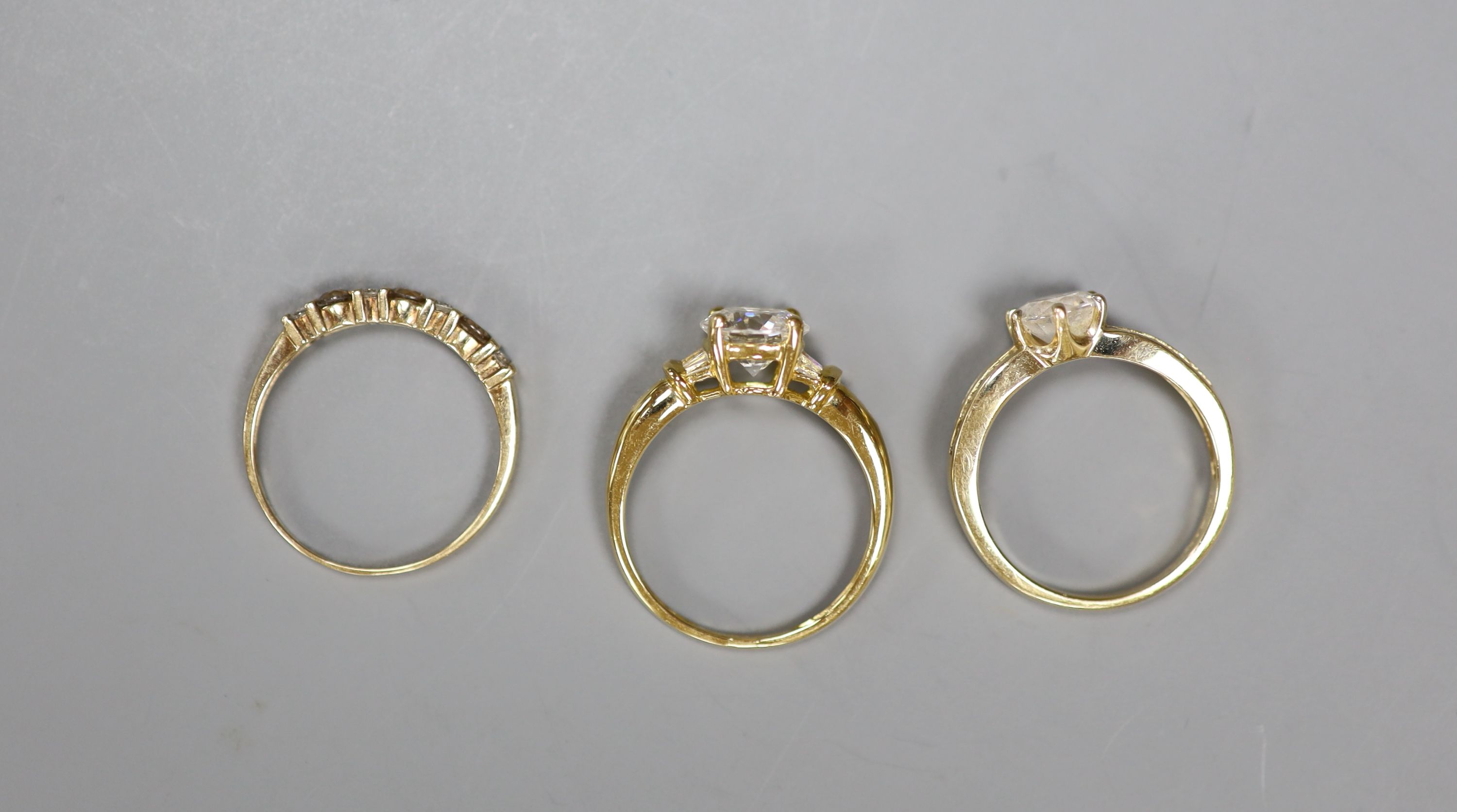 An 18ct gold paste-set solitaire ring, a similar 14ct gold ring and a 9ct gold, diamond and gem-set ring